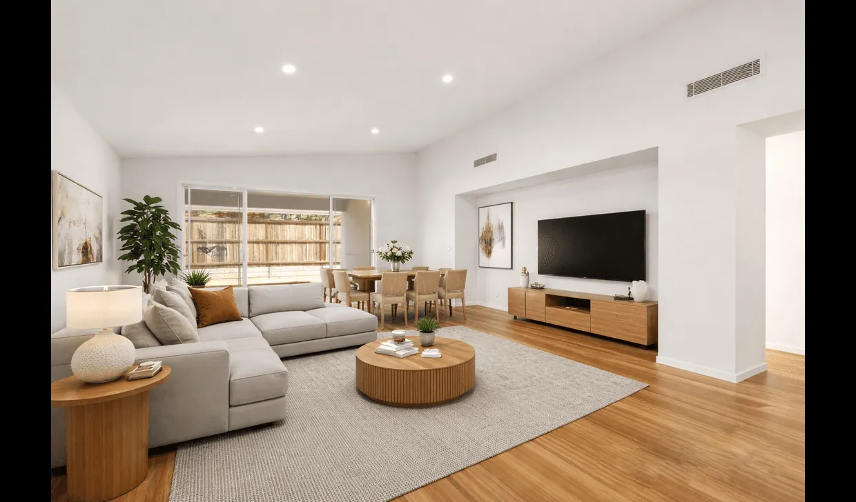 Open living and dining space with raked ceiling and timber floors