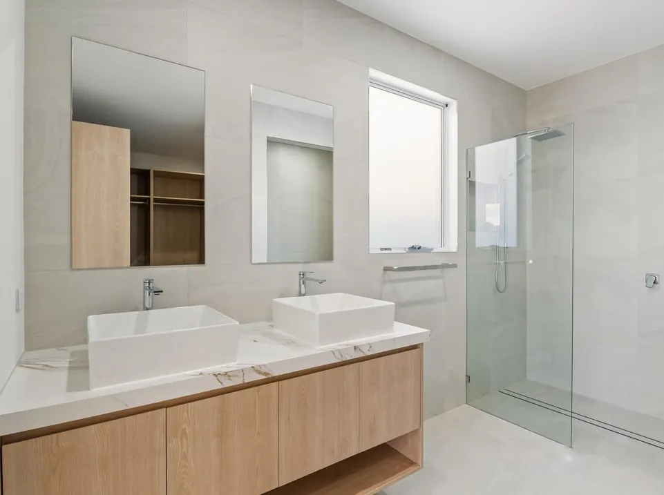 Ensuite with twin vessel basins, stone-look tiling and walk-in shower