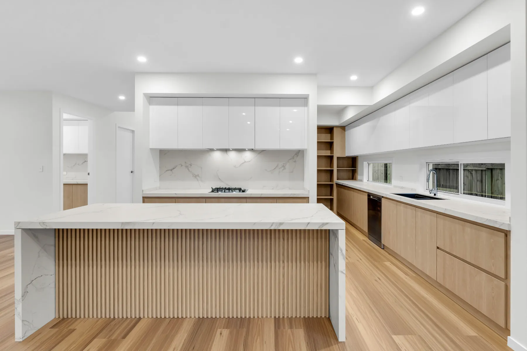 Kitchen with marble-look island, fluted timber detailing and oak cabinetry